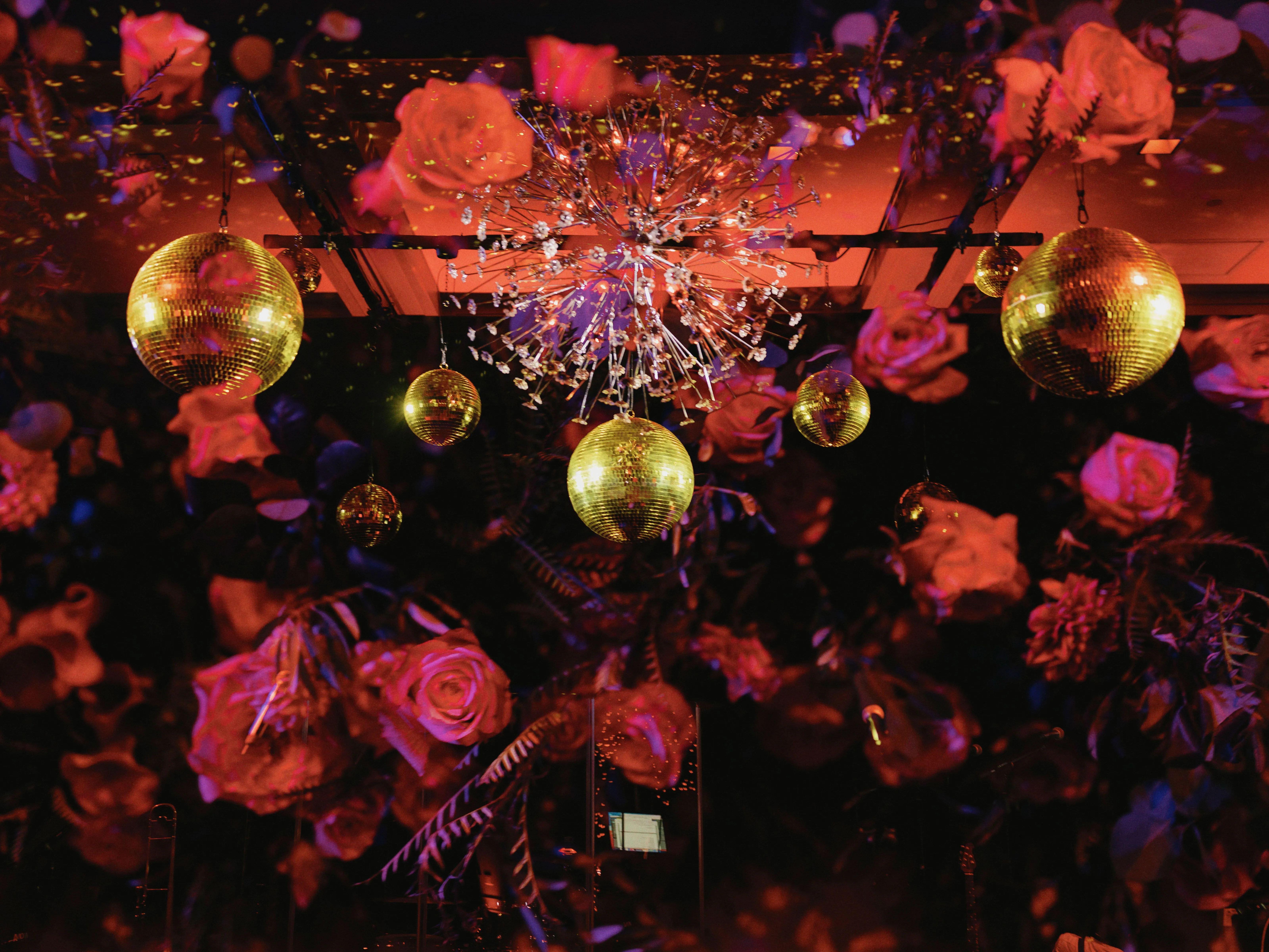 Close-up of a mirror ball and florals glowing under precisely aimed accent lighting