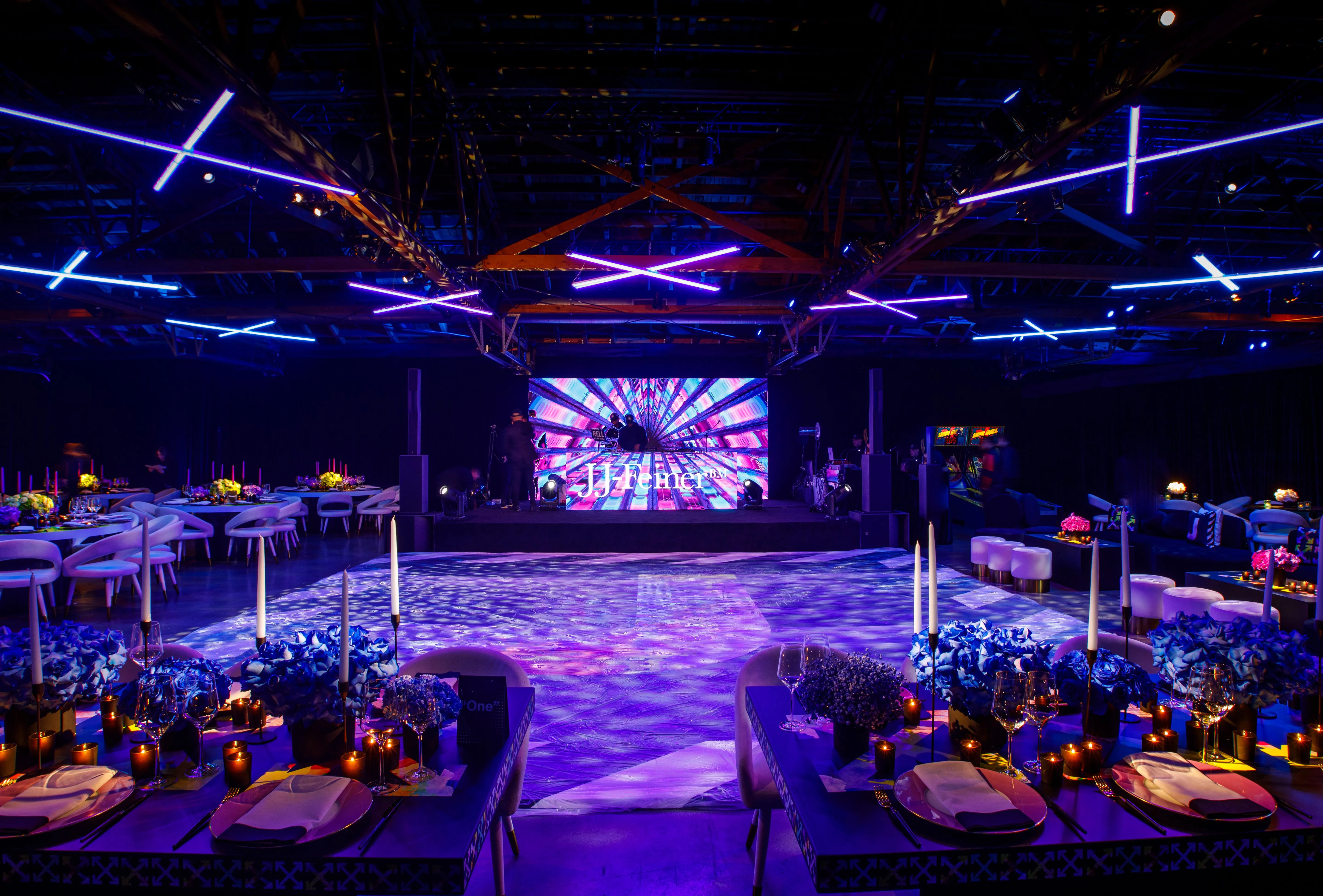 Mitzvah party in a warehouse venue with neon tube ceiling lighting, LED screen stage, and lit dance floor